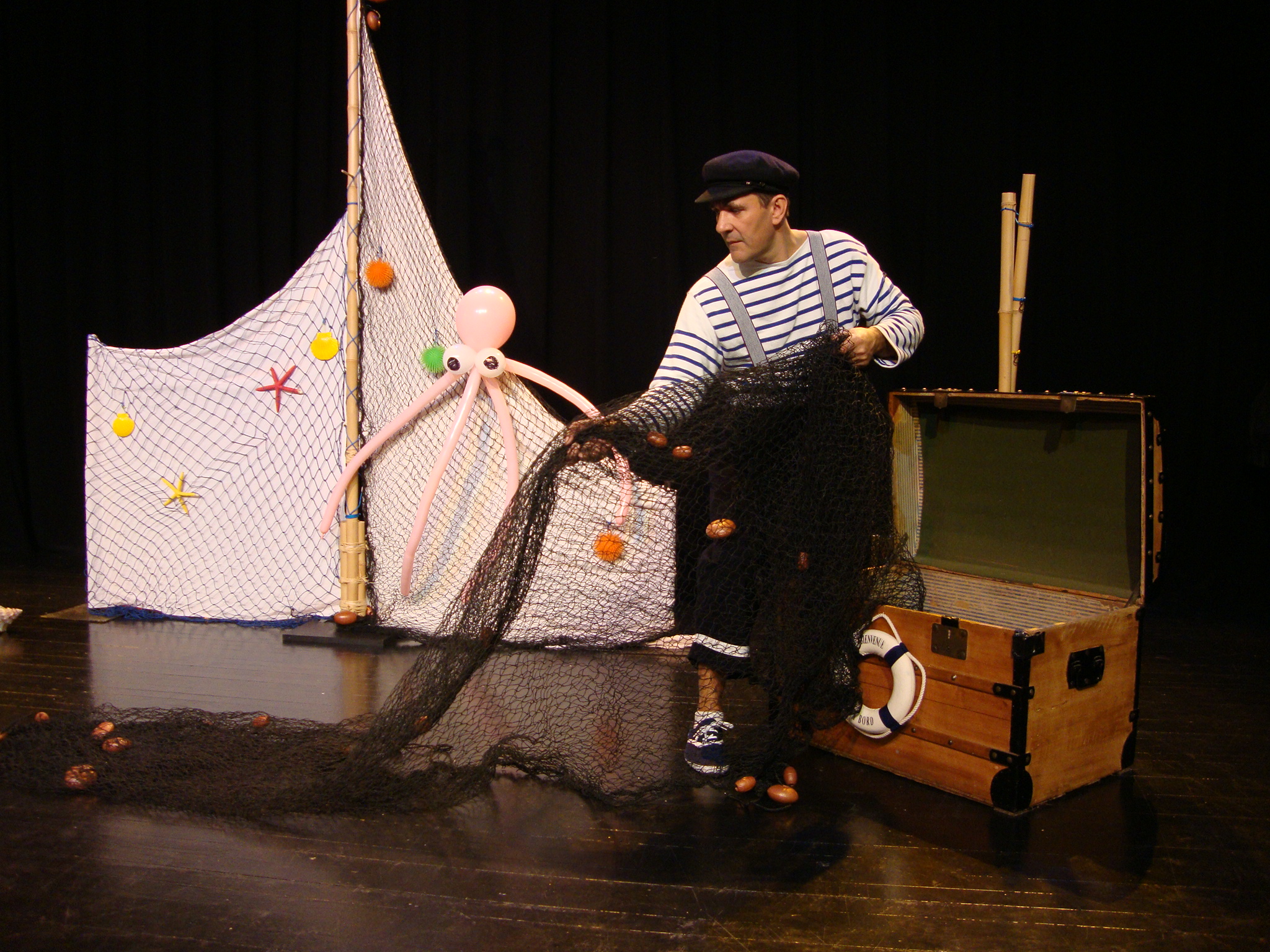 Marin qui range son filet de pêche dans un coffre de pirate. Cirkonflex
